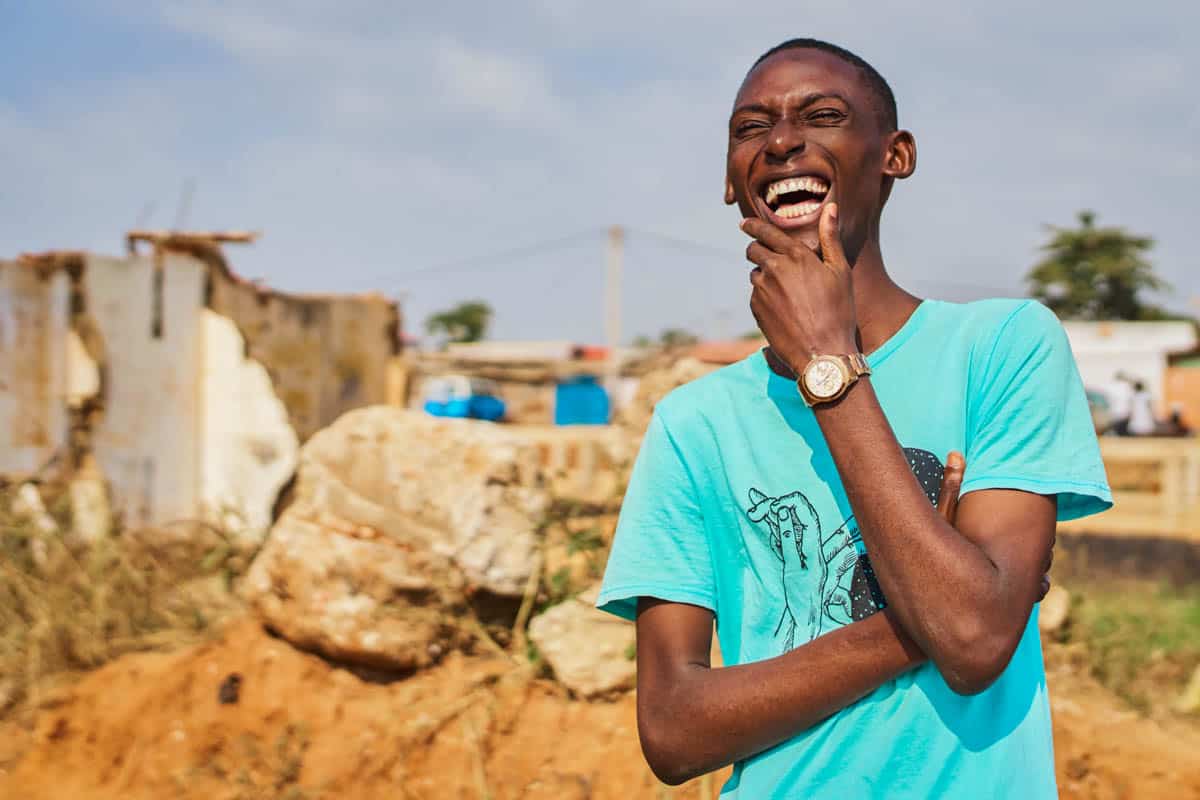 Happy man smiling and laughing, standing outside with construction in the background.